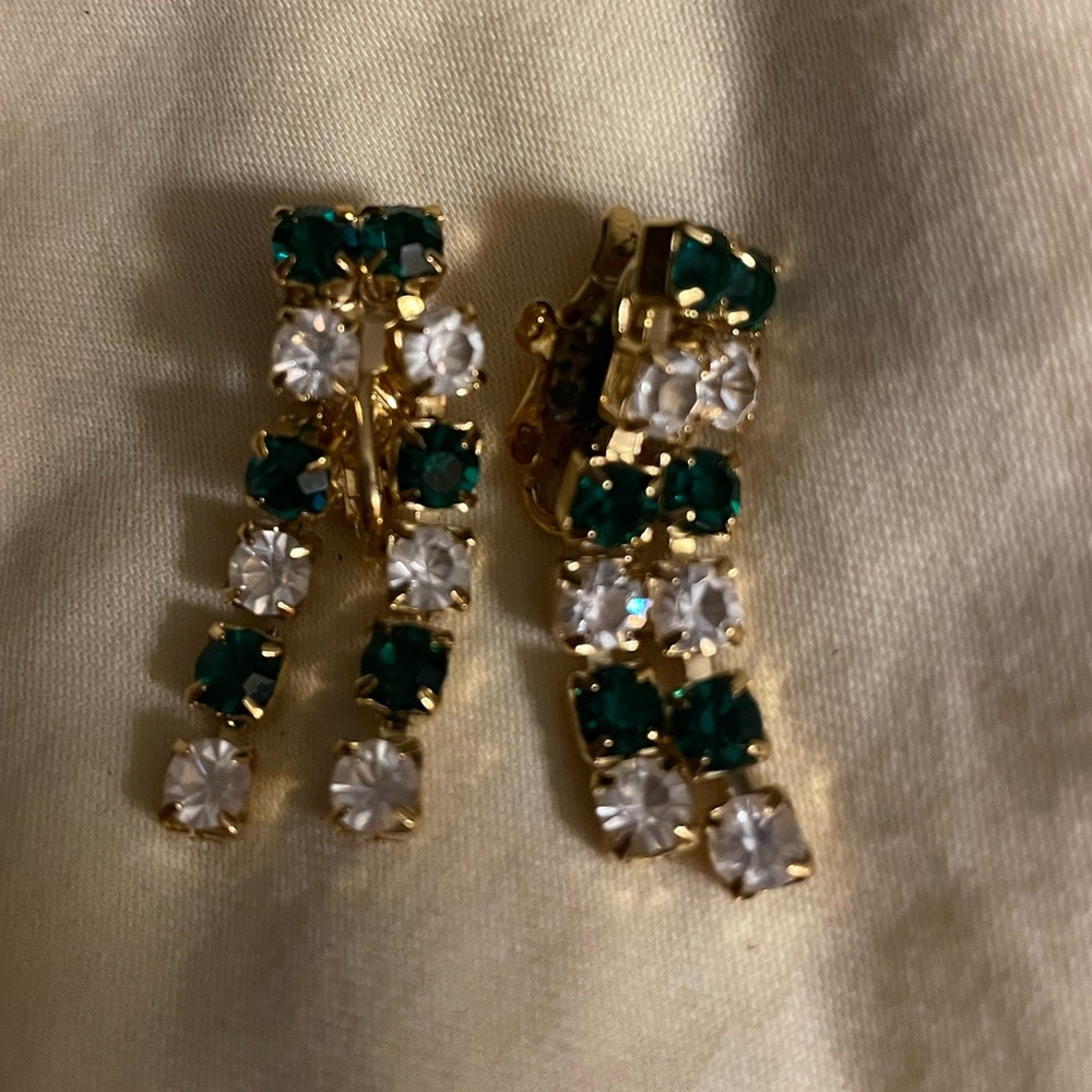 Clip on Trifari earrings with green and clear rhinestones on gold.